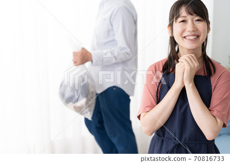 一位年輕的家庭主婦要求她的丈夫拿出垃圾桶 一位年輕的家庭主婦要求她的丈夫拿出垃圾桶 70816733