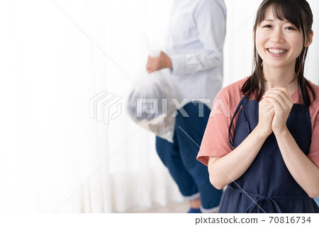 一位年輕的家庭主婦要求她的丈夫拿出垃圾桶 70816734