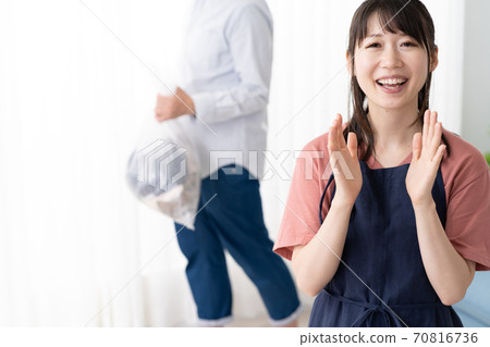 一位年輕的家庭主婦要求她的丈夫拿出垃圾桶 一位年輕的家庭主婦要求她的丈夫拿出垃圾桶 70816736