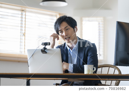 Telework image of a man frowning while looking at a computer screen Telework image of a man frowning while looking at a computer screen 70816982