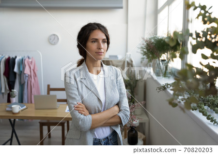 Dreamy female designer look in distance thinking visualizing 70820203