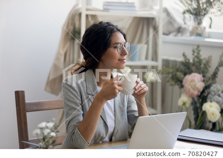 Happy young businesswoman drink coffee dreaming in home office 70820427