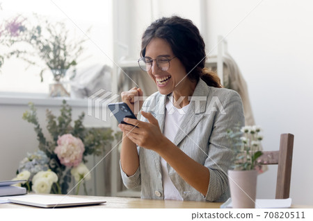 Overjoyed woman triumph read good news on cell 70820511