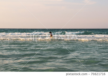Woman walking on the  white sandy beach and turquoise water in Caribbean Beach in Tulum, Mexico 70821716