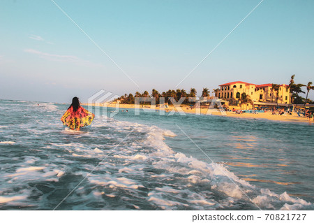 Woman walking on the  white sandy beach and turquoise water in Caribbean Beach in Tulum, Mexico 70821727