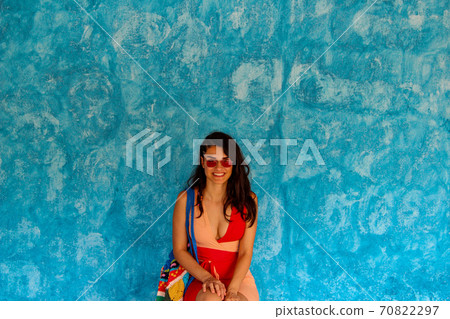 girl sitting in front of the blue street wall in Sayulita girl sitting in front of the blue street wall in Sayulita 70822297