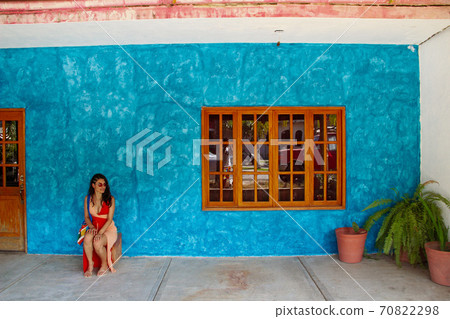 girl sitting in front of the blue street wall in Sayulita girl sitting in front of the blue street wall in Sayulita 70822298