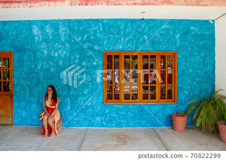 girl sitting in front of the blue street wall in Sayulita girl sitting in front of the blue street wall in Sayulita 70822299
