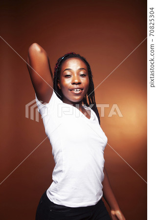 pretty young african american woman with braids posing cheerful gesturing on brown background, lifestyle people concept pretty young african american woman with braids posing cheerful gesturing on brown background, lifestyle people concept 70825304