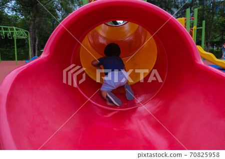 Little boy playing on playground park enjoying slider 70825958