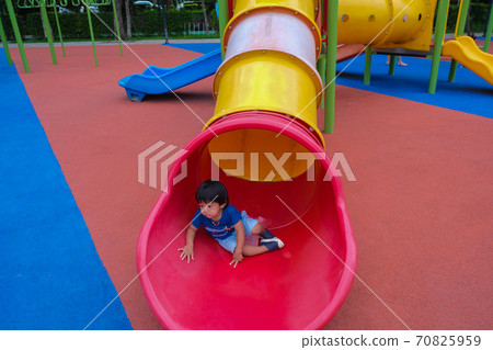 Little boy playing on playground park enjoying slider 70825959