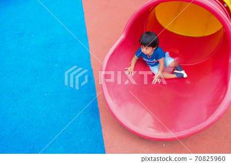 Little boy playing on playground park enjoying slider 70825960
