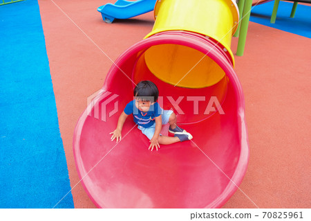 Little boy playing on playground park enjoying slider 70825961