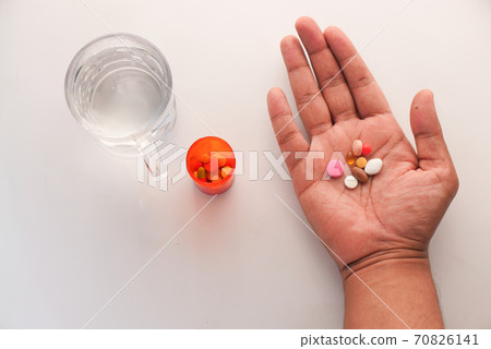 Close up of man hand taking medicine Close up of man hand taking medicine 70826141