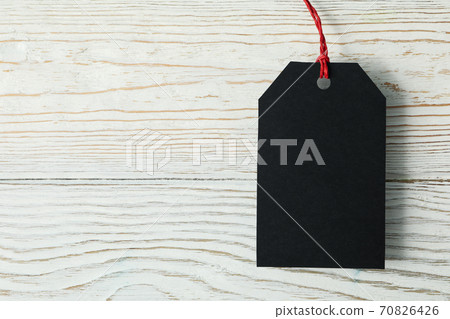 Blank black tag on white wooden background Blank black tag on white wooden background 70826426
