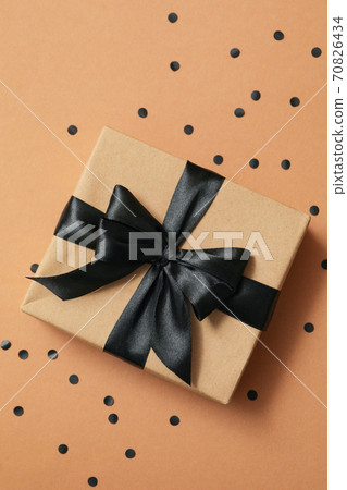 Gift box with black bow on craft background Gift box with black bow on craft background 70826434