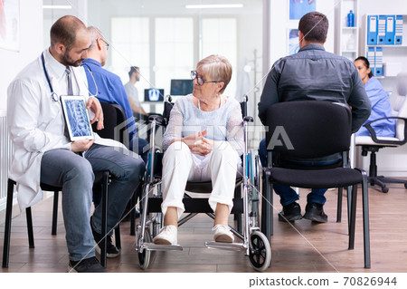 Handicapped woman discussing with doctor Handicapped woman discussing with doctor 70826944