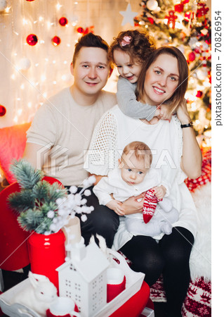 kissing parents with hugging kids at Christmas. 70826954