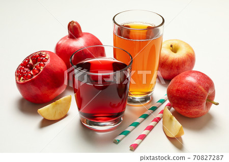 Glasses with apple and pomegranate juices on white background Glasses with apple and pomegranate juices on white background 70827287