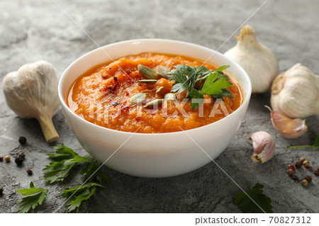 Composition with bowl of pumpkin soup on gray background, close up Composition with bowl of pumpkin soup on gray background, close up 70827312