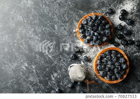 Concept of tasty lunch with blueberry pies on dark background Concept of tasty lunch with blueberry pies on dark background 70827313
