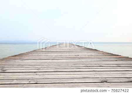 The view along a wooden pier from the resort town of Sirmione on the banks of Lake Garda in north east Italy. The view along a wooden pier from the resort town of Sirmione on the banks of Lake Garda in north east Italy. 70827422