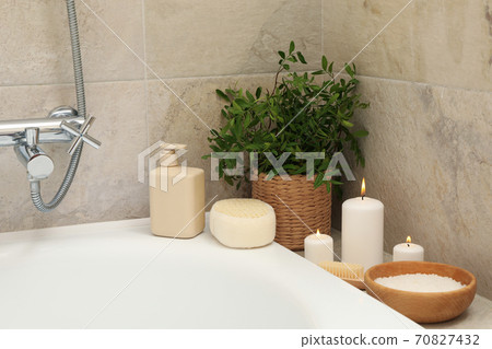 Bath with personal hygiene accessories in light beige bathroom 70827432