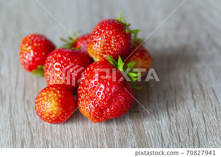Pile of strawberries on a grey stone background. Selective focus 70827941