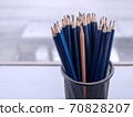 Blue pencils and one different brown sharp pencil standing out in pencil case. Leadership growth in business and different culture concept. 70828207