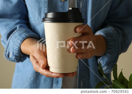 Woman hold blank paper cup, front view 70829581