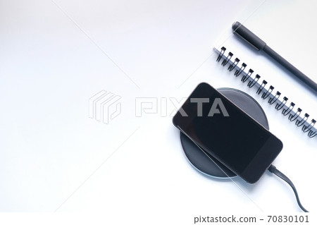 charging Smartphone Using Wireless Charging Pad, top view charging Smartphone Using Wireless Charging Pad, top view 70830101