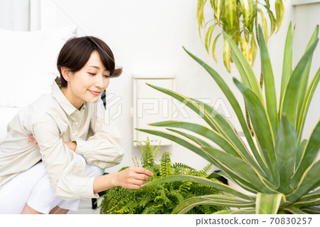 A woman enjoying gardening on the balcony 70830257