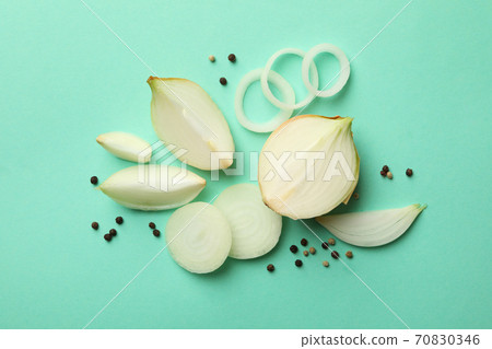 Fresh onion and peppercorns on mint background, top view Fresh onion and peppercorns on mint background, top view 70830346
