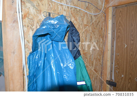 Hanging a raincoat on a hanger after the rain 70831035