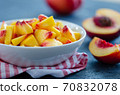 Chopped peaches  on a  table,  closeup. 70832078