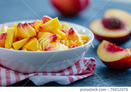 Chopped peaches  on a  table,  closeup. 70832078