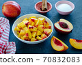 Chopped peaches and whole peache on a  table,  closeup. 70832083