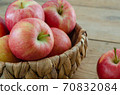 Red apples are in the basket on wooden table 70832084