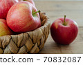 Red apples are in the basket on wooden table 70832087