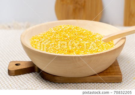 Corn grits in a wooden bowl. The concept of the production of cereals from grain, products from corn. 70832205
