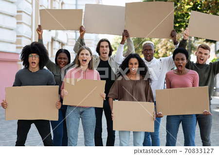 Furious mutiracial group of demonstrators protesting on the street Furious mutiracial group of demonstrators protesting on the street 70833127