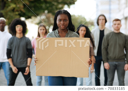Black woman with empty placard leading group of protestors Black woman with empty placard leading group of protestors 70833185