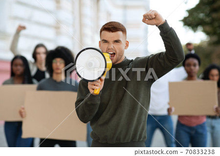 Young man with megaphone leading international group of protestors Young man with megaphone leading international group of protestors 70833238