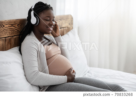 Pregnancy Leisure. Calm Black Pregnant Woman Listening Music In Headphones At Home 70833268