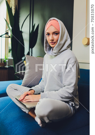 Portrait of a beautiful, elegant and attractive young Malay Asian Muslim woman in a dress and an hijab head scarf. 70833870