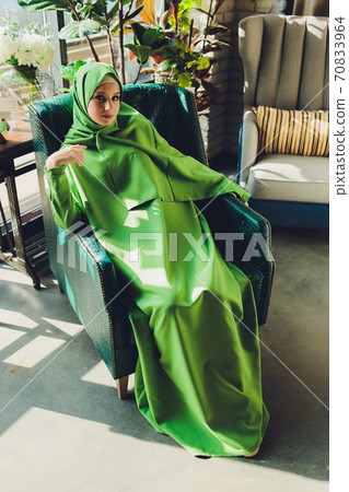 Portrait of a beautiful, elegant and attractive young Malay Asian Muslim woman in a dress and an hijab head scarf. Portrait of a beautiful, elegant and attractive young Malay Asian Muslim woman in a dress and an hijab head scarf. 70833964