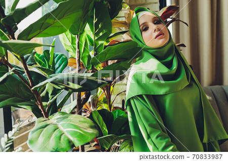 Portrait of a beautiful, elegant and attractive young Malay Asian Muslim woman in a dress and an hijab head scarf. Portrait of a beautiful, elegant and attractive young Malay Asian Muslim woman in a dress and an hijab head scarf. 70833987