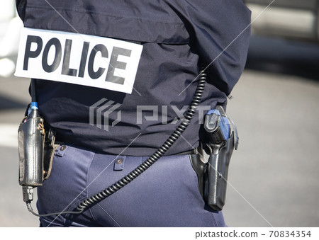 Policeman in outfit, view from the back on the street. Policeman in outfit, view from the back on the street. 70834354