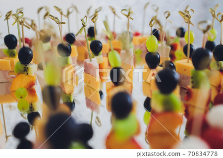 Canape, appetizers, on the table, buffet menu, European cuisine, shrimp, mini burger on a wooden background. Canape, appetizers, on the table, buffet menu, European cuisine, shrimp, mini burger on a wooden background. 70834778