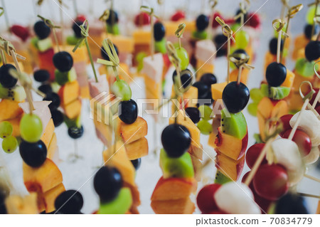 Canape, appetizers, on the table, buffet menu, European cuisine, shrimp, mini burger on a wooden background. Canape, appetizers, on the table, buffet menu, European cuisine, shrimp, mini burger on a wooden background. 70834779